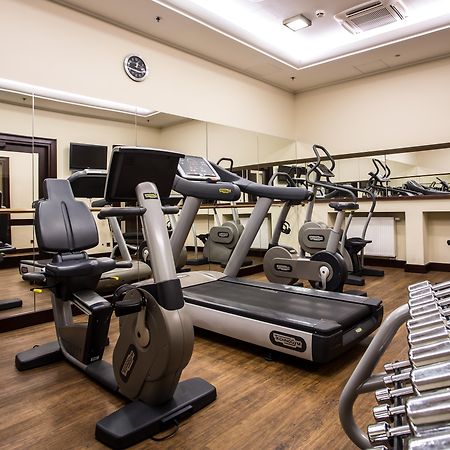 Radisson Blu Hotel, Danzica Esterno foto The photo displays a small gym or fitness room. The room features various exercise equipment, including a treadmill, an elliptical machine, and a set of dumbbells arranged on a rack. There are mirrors on the wall, which help create a sense of space a