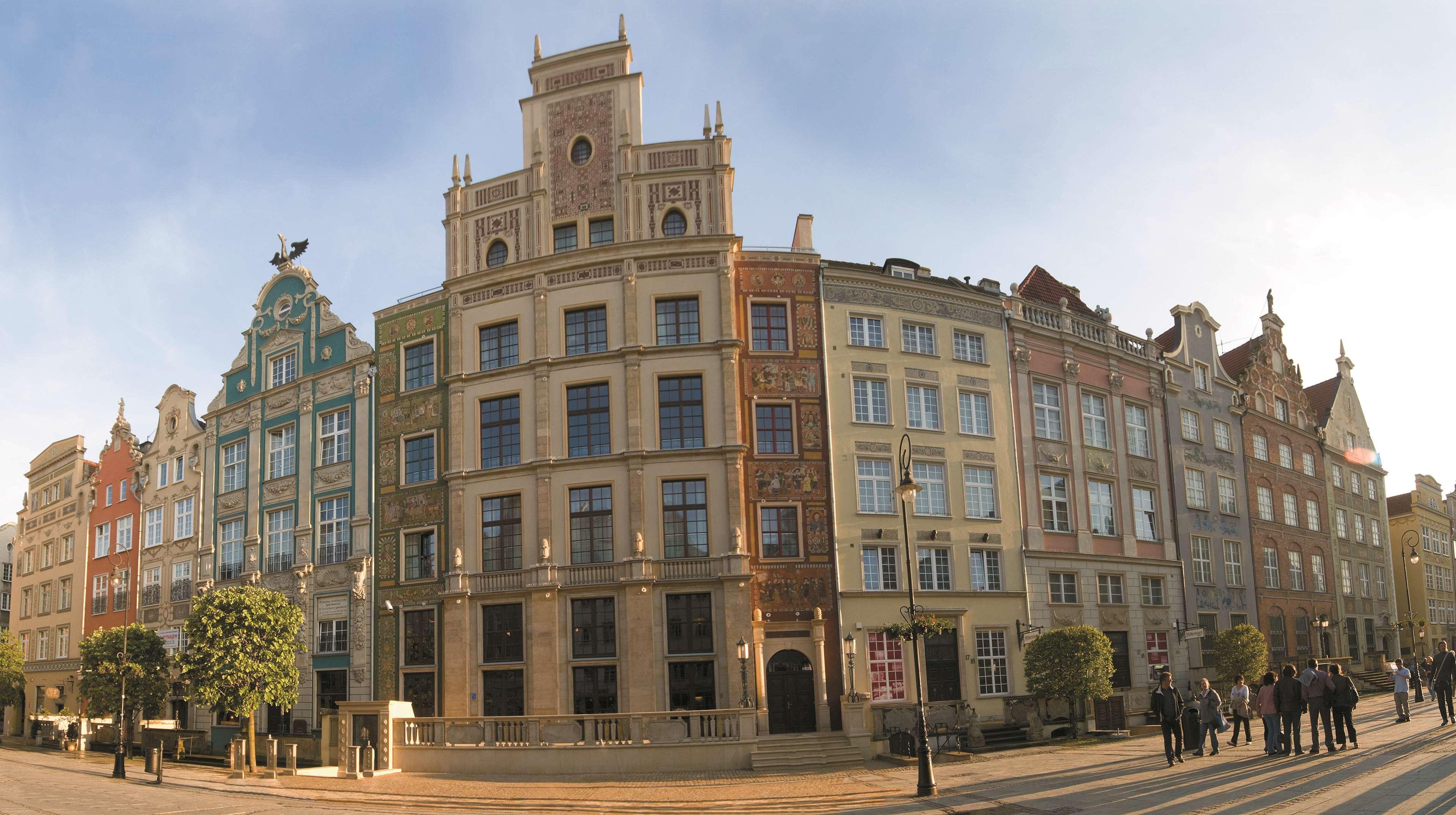 Radisson Blu Hotel, Danzica Esterno foto The photo showcases a panoramic view of a row of historic buildings, likely in a European city. The architecture features a blend of styles, presenting a vibrant facade with multiple colors and decorative elements. Each building has distinct characte