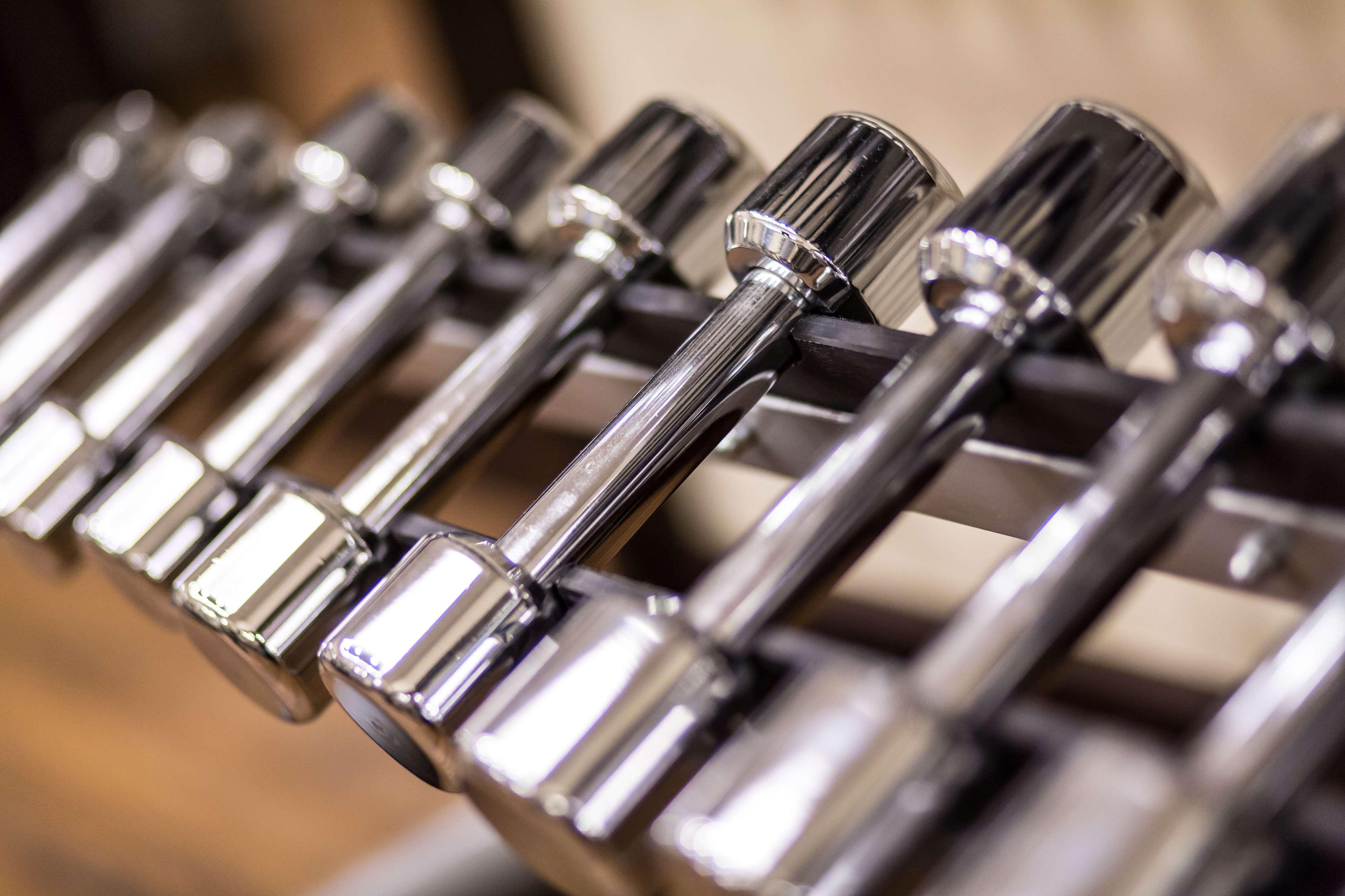 Radisson Blu Hotel, Danzica Esterno foto The photo shows a close-up view of a row of chrome dumbbells arranged on a rack. The dumbbells have a shiny metallic finish, highlighting their weight and design. They vary in size, indicating different weights, and are typically used for strength tr