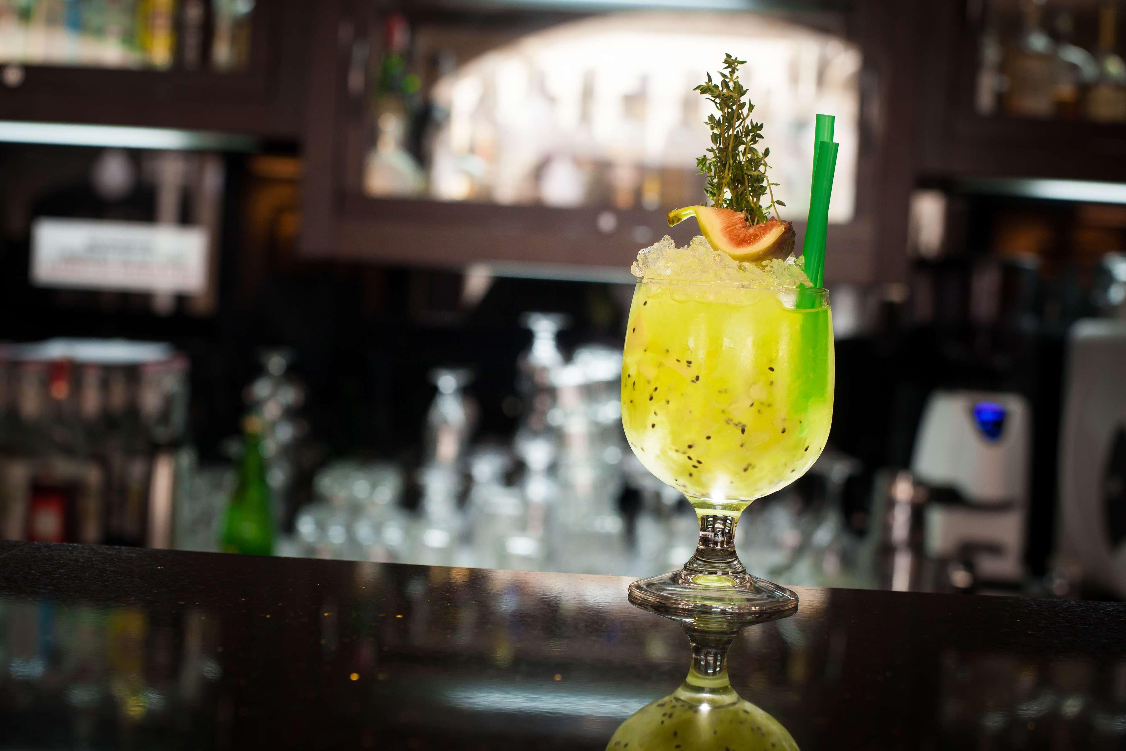 Radisson Blu Hotel, Danzica Esterno foto The photo shows a vibrant, green cocktail served in a stylish glass with a wide base and an elegant stem. The drink is garnished with a slice of fruit and a sprig of herbs, adding visual appeal. A green straw is inserted into the drink, and it appear