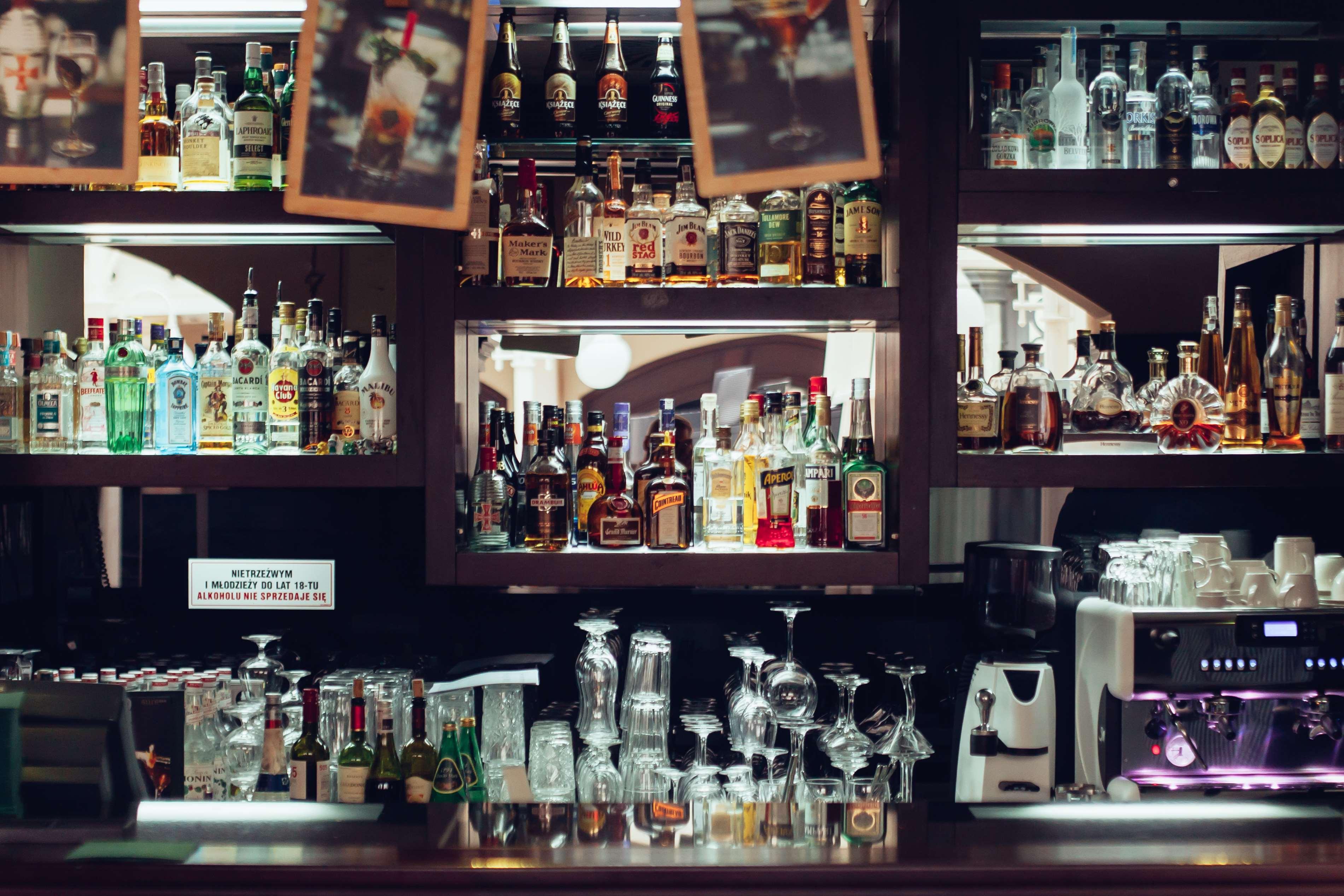 Radisson Blu Hotel, Danzica Esterno foto The photo depicts a bar area featuring a wide variety of alcoholic beverages neatly arranged on shelves. The shelves are filled with bottles of different sizes and colors, including spirits and liquors. In the foreground, there are several glassware 