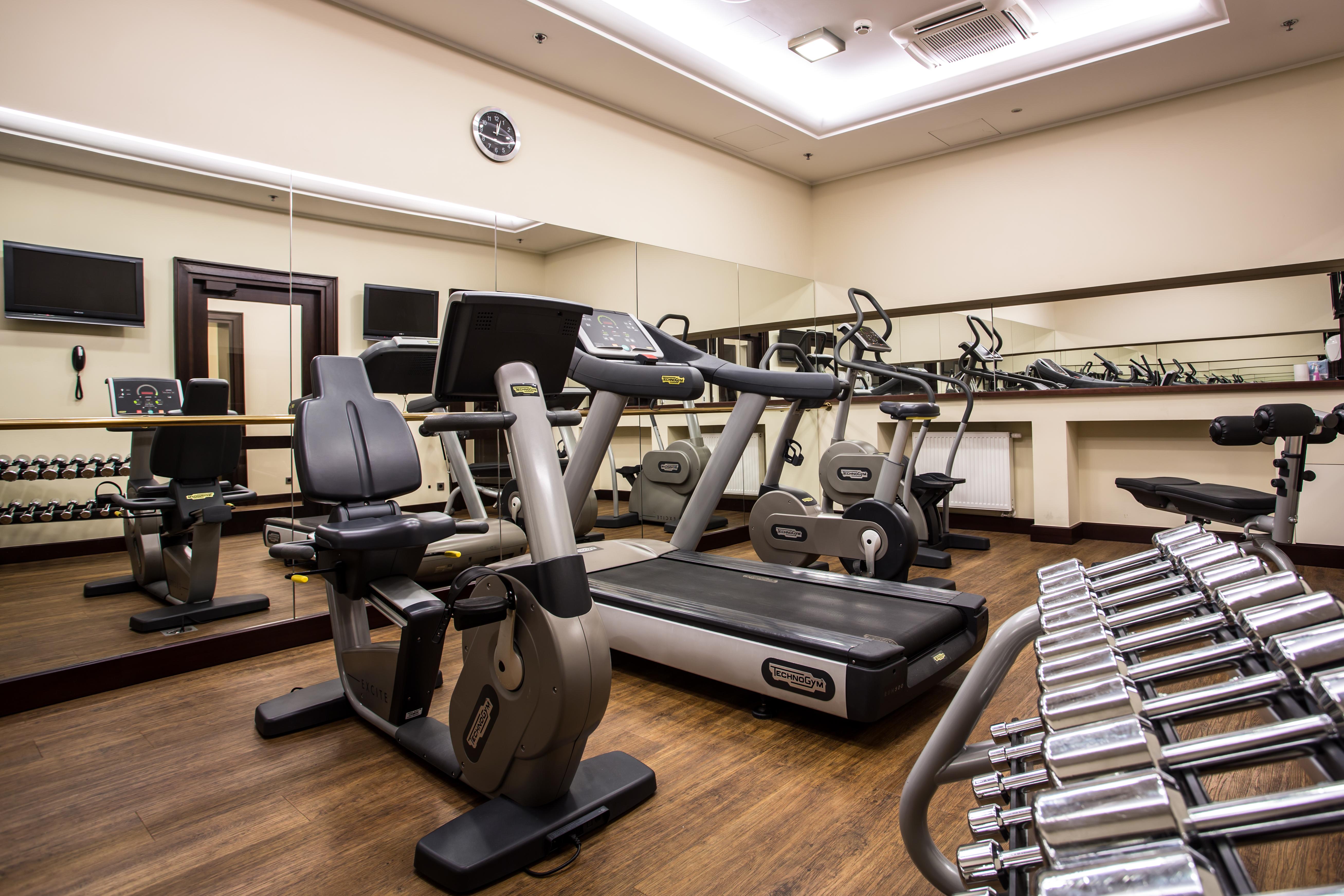 Radisson Blu Hotel, Danzica Esterno foto The photo displays a small gym or fitness room. The room features various exercise equipment, including a treadmill, an elliptical machine, and a set of dumbbells arranged on a rack. There are mirrors on the wall, which help create a sense of space a